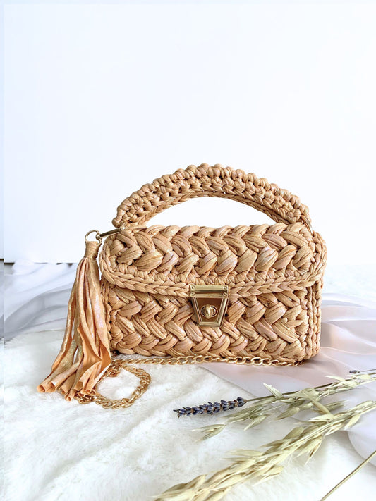 Beige handcrafted crochet bag with a sophisticated shimmer, perfect for any occasion.