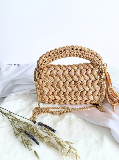 Meticulously crafted beige crochet handbag with detachable chain for versatile styling.