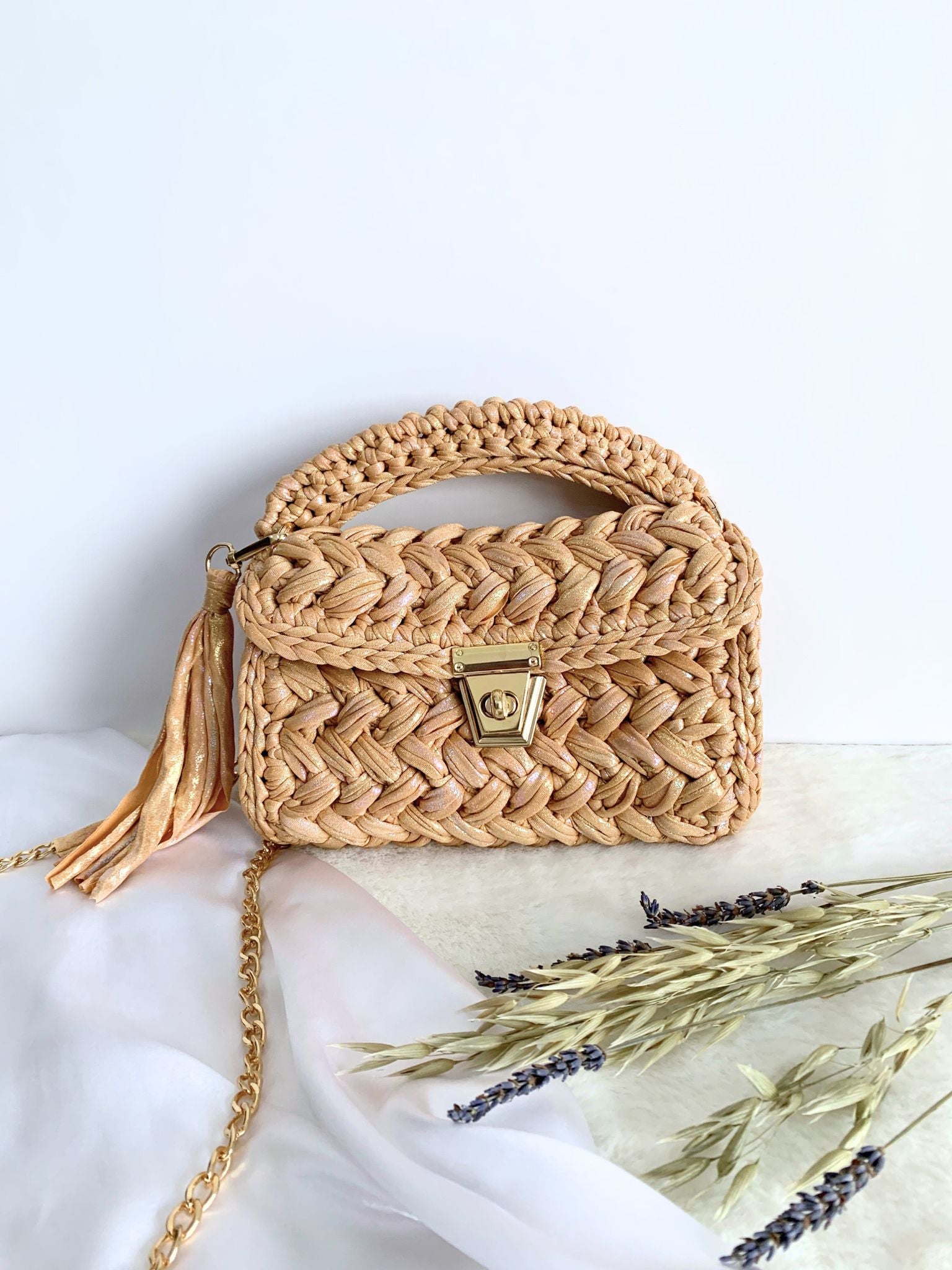 Beige crochet bag with a touch of sophistication and a detachable chain for easy styling.