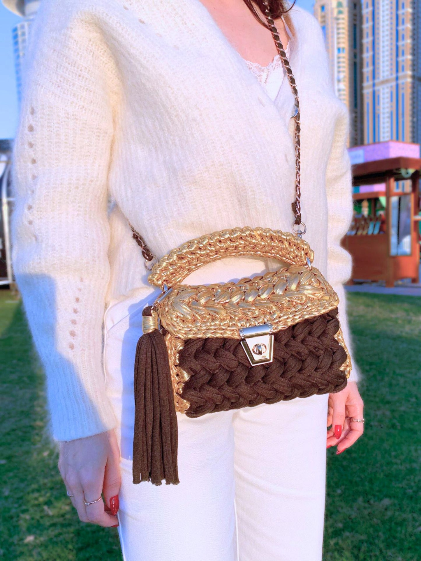 Electric black and gold crochet handbag with tassel and detachable chain.