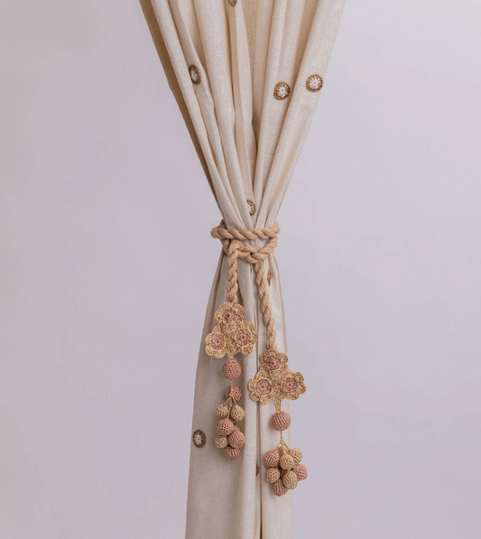 Subtle and elegant crocheted curtain tie backs adorned with delicate flowers and beads.