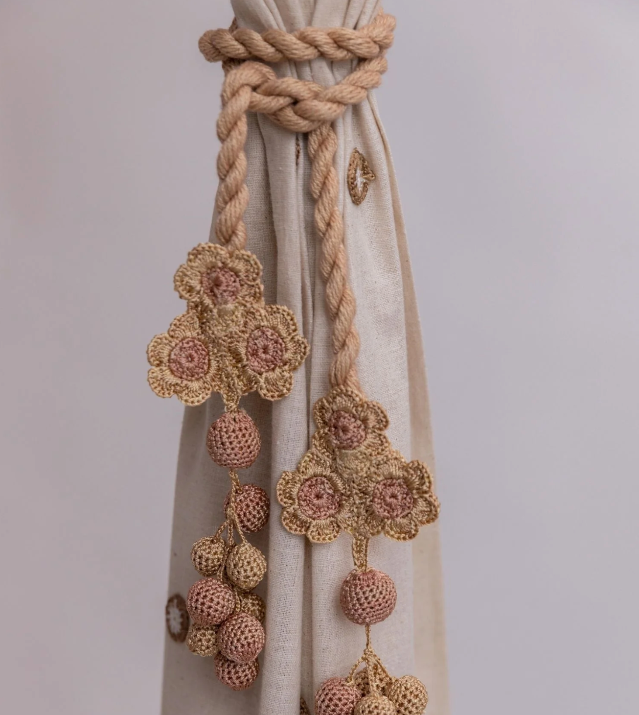 Subtle and refined curtain tie backs crafted with delicate crochet work, flowers, and beads.