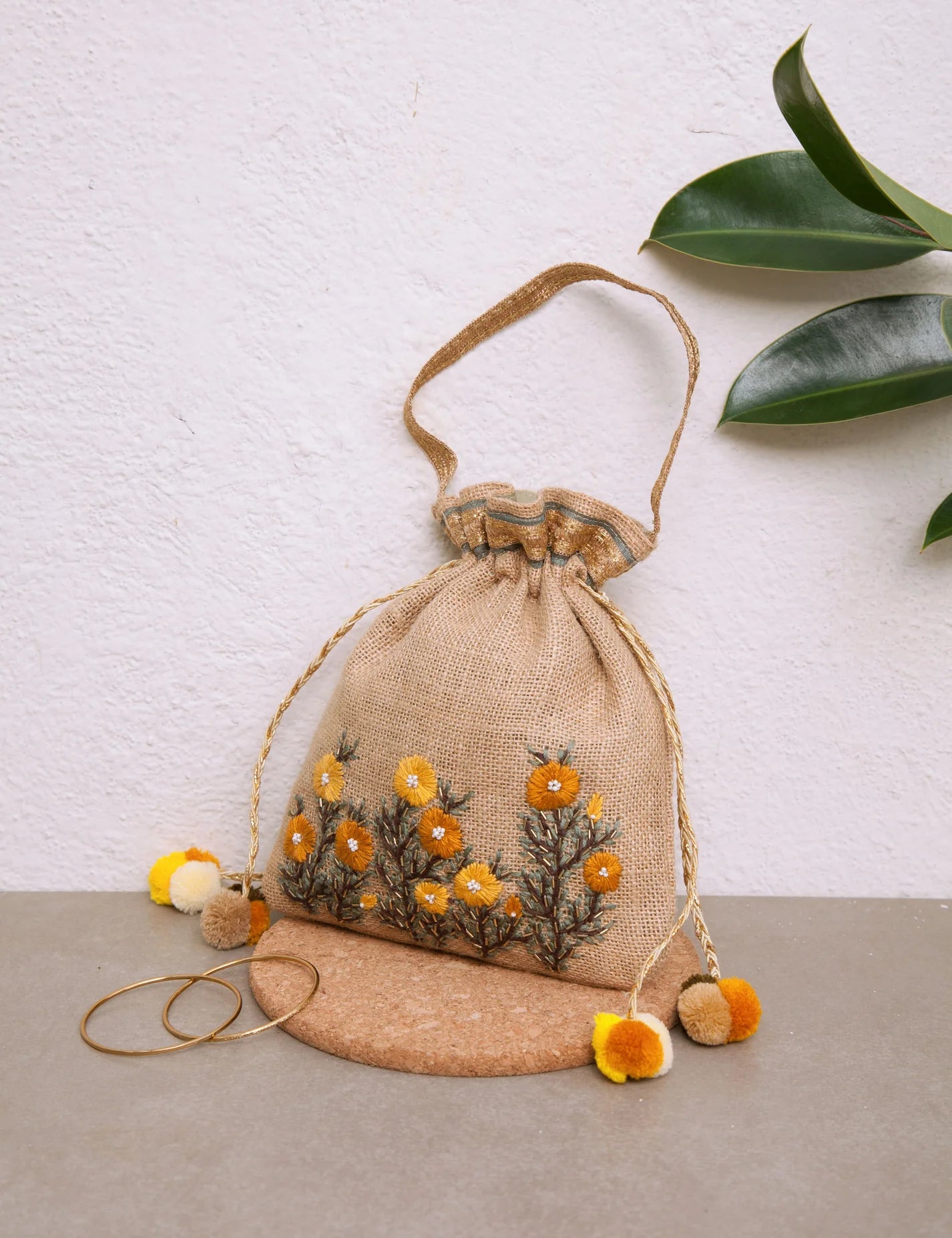 Our Buttercup Potli bag has hand-embroidered buttercup blooms on a Jute potli,