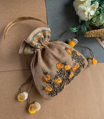 Our Buttercup Potli bag has hand-embroidered buttercup blooms on a Jute potli,