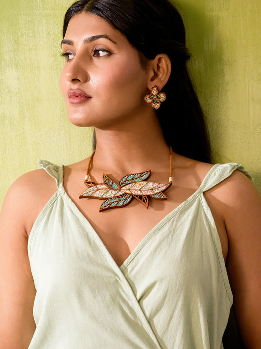 Stylish neckpiece featuring intricate leaf design and glass bead embellishments.