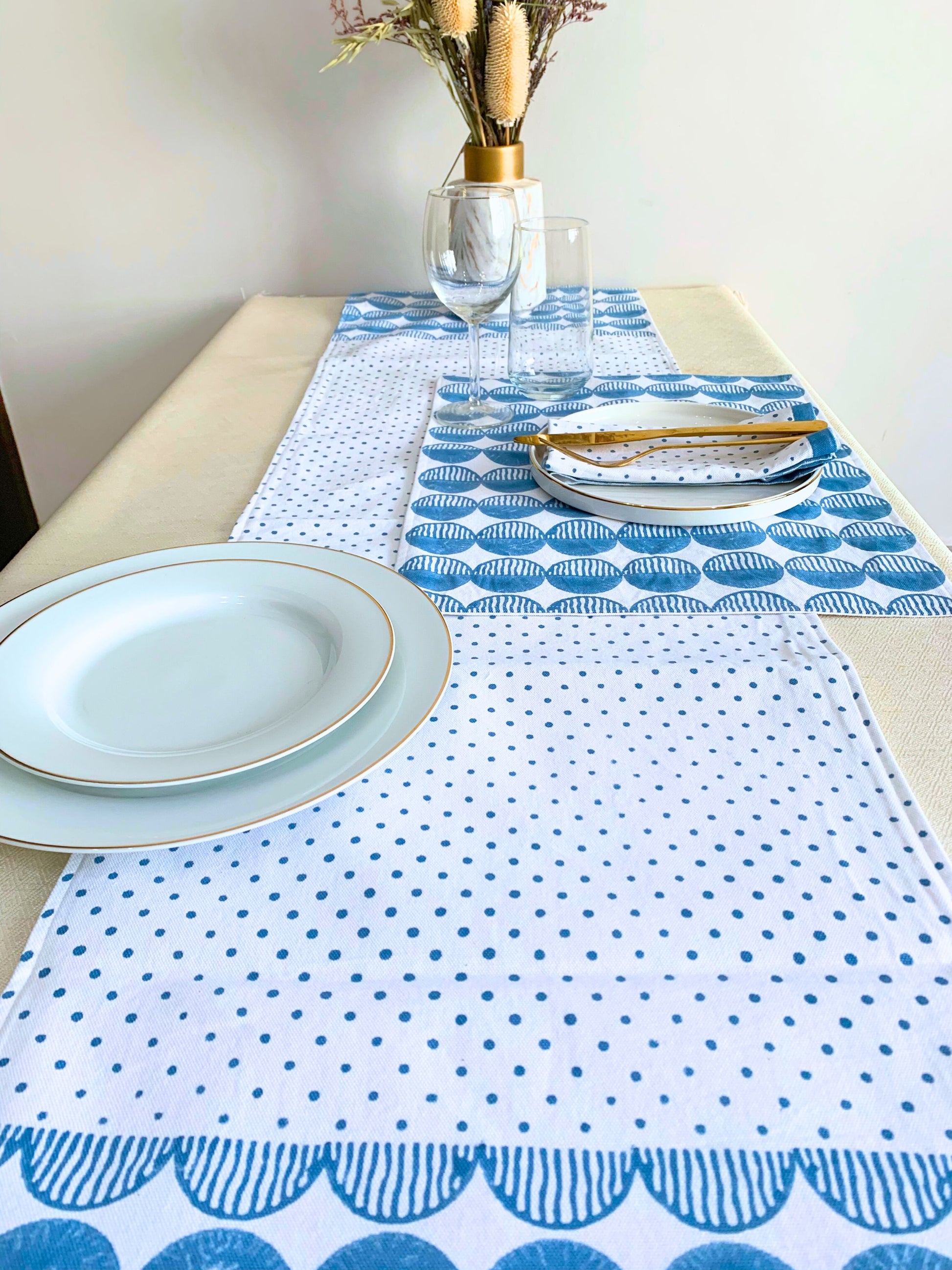 Blue table runner with rhythmic circles and polka dots on organic cotton.