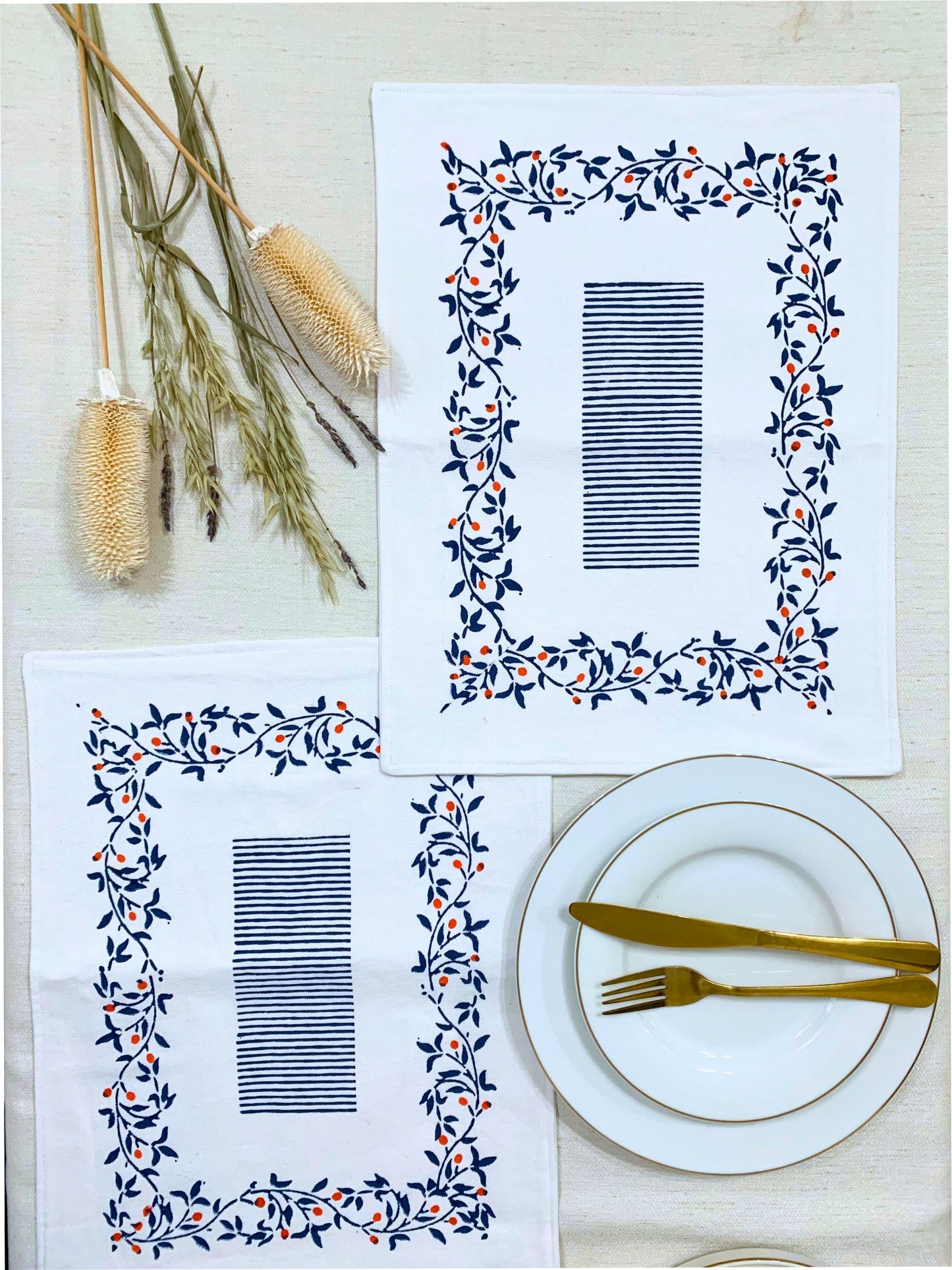 Eco-friendly placemats with a block-printed floral pattern and sketchy lines, crafted from GOTS certified organic cotton for a sustainable dining experience. Set of 6 in blue.