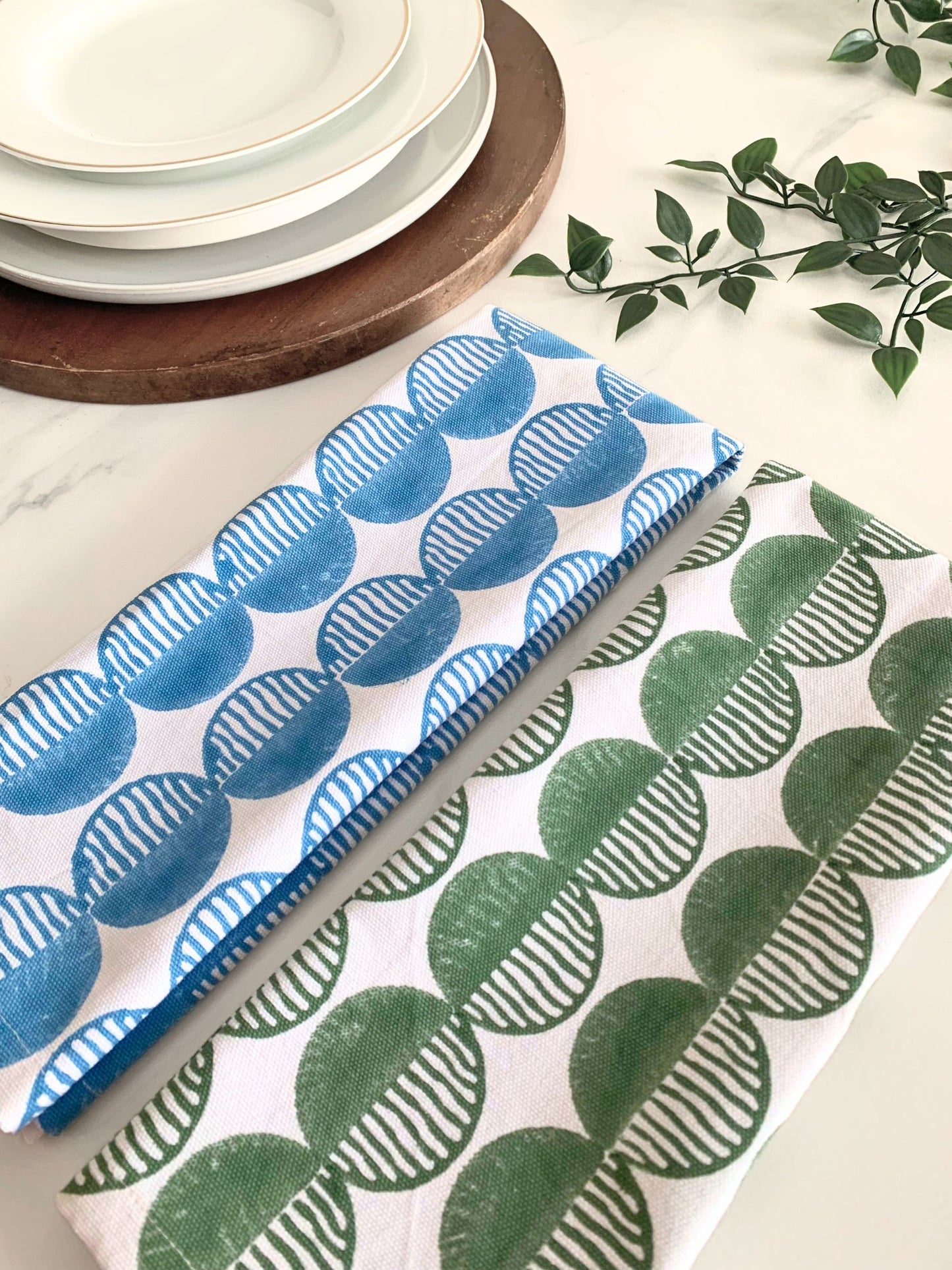 Set of 2 tea towels with a rhythmic block-printed circle pattern, crafted from durable organic cotton for an eco-conscious kitchen.