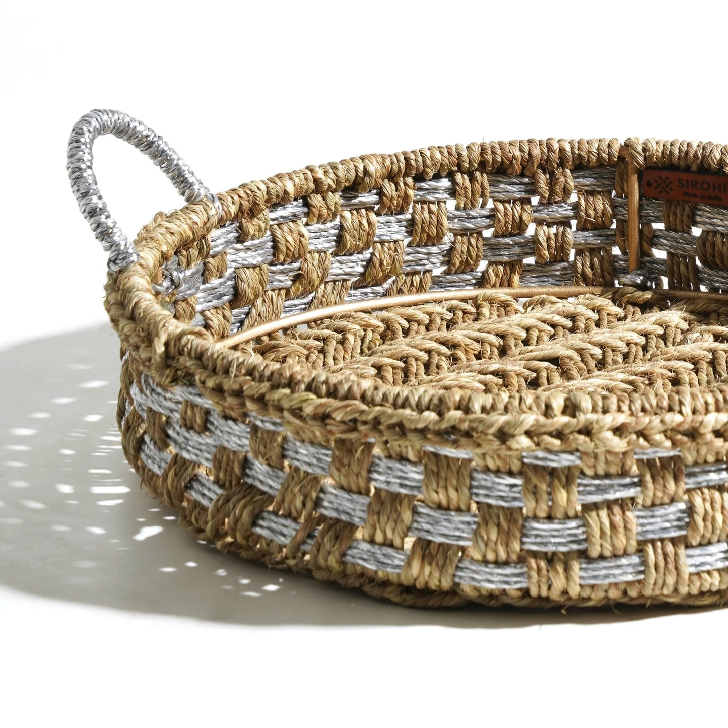 Luxurious handwoven tray crafted from natural grass and upcycled plastic. Woven in shades of natural and silver.