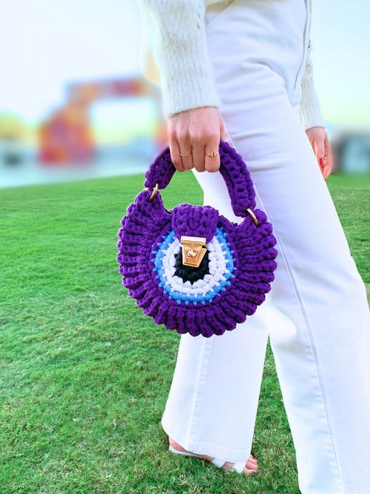 Handcrafted crochet bag with a captivating vibrant evil eye design for a touch of charm.