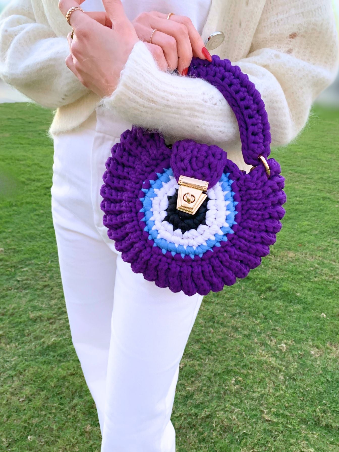 Discover craftsmanship and charm in this unique handcrafted crochet bag with a vibrant evil eye.