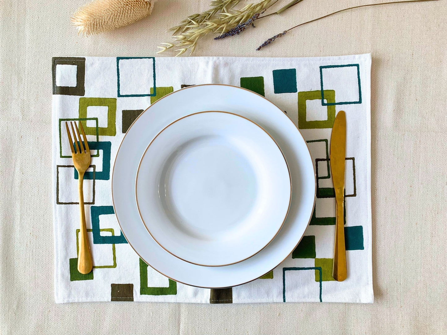 Block printed placemats in shades of green.