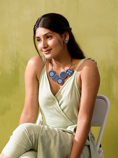 Tribal contemporary jewelry with hand-painted details on indigo fabric.