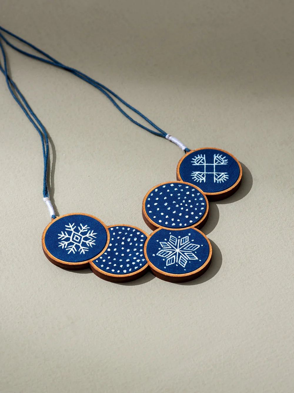 Hand-painted necklace featuring indigo-colored fabric with intricate painting.