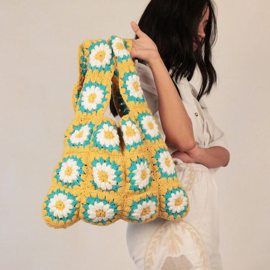 Hand-crocheted shopper tote bag featuring an open design and charming floral patchwork motifs