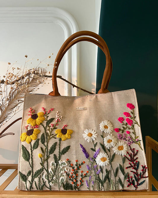 Experience elegance and sustainability with our Handcrafted Garden Tote Bag, featuring a stunning hand-embroidered floral design on natural-colored sustainable fabric.