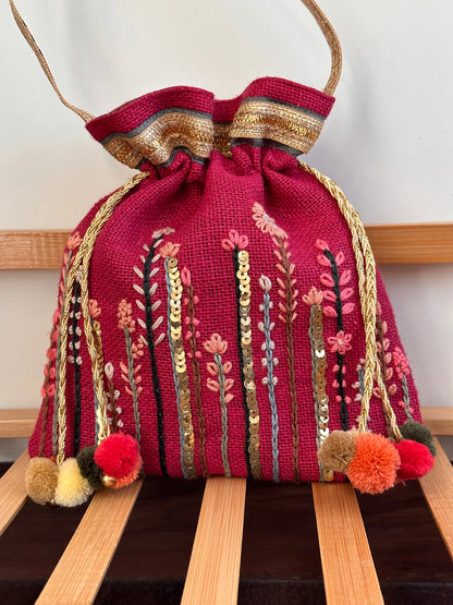 Intricately hand-embroidered Pink Floral Potli bag adorned with metal sequins, capturing a vibrant flower field.