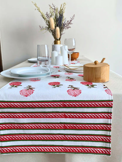 GOTS certified organic cotton table runner in white, adorned with vibrant red and green block printed motifs, offering a perfect blend of style and sustainability.