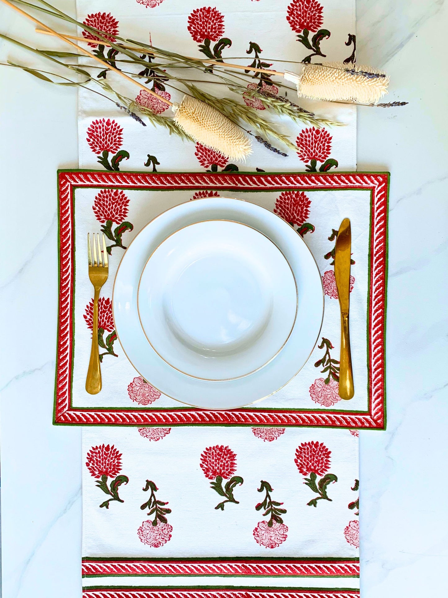 Sustainable elegance for your table – white table runner with delicate block printed motifs in vibrant red and green, made from GOTS certified organic cotton.