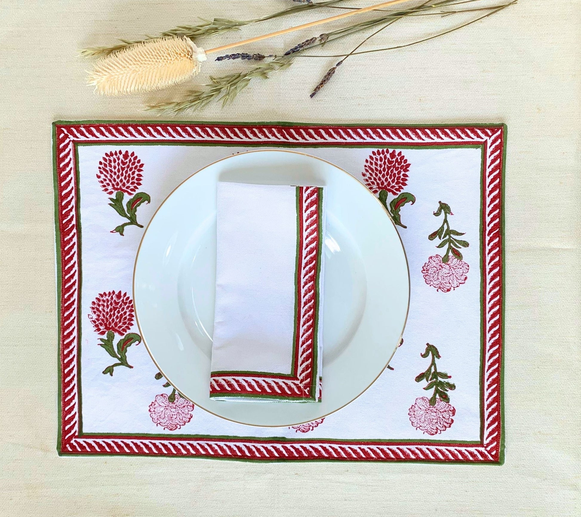 White placemats crafted from GOTS certified organic cotton, showcasing delicate block printed motifs in vibrant red and green for a touch of sophistication.