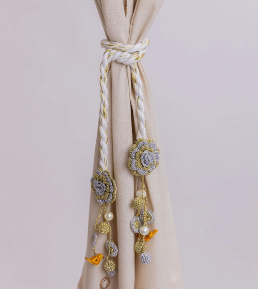 Crocheted curtain tie backs with flower and bird detail for secure and stylish drapery.