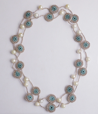 Elegant crocheted necklace with delicate motifs and lustrous pearl beads.