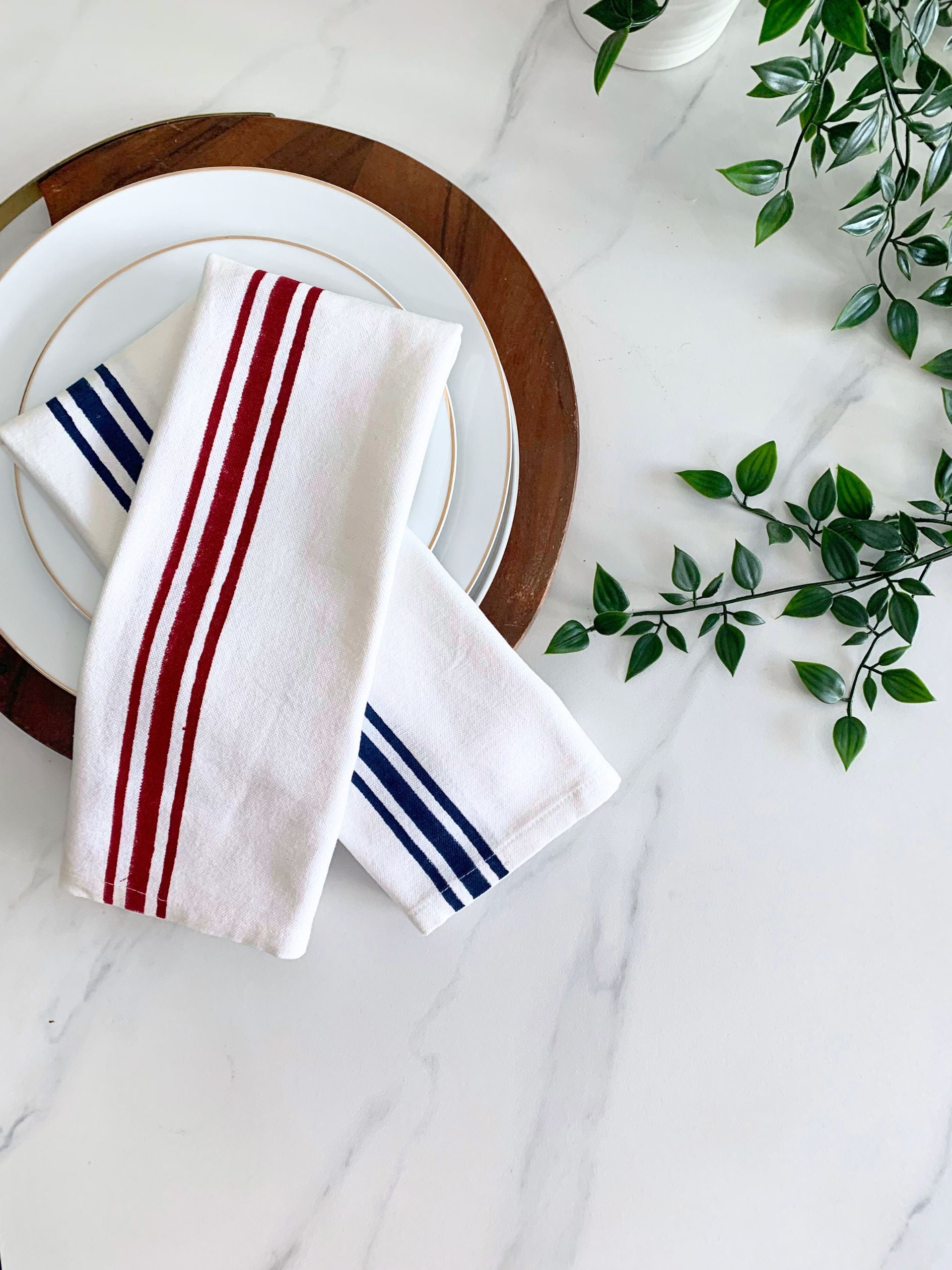 Tea towels with maroon and blue block printed line borders on GOTS certified organic cotton, providing a sustainable alternative to traditional paper kitchen towels.