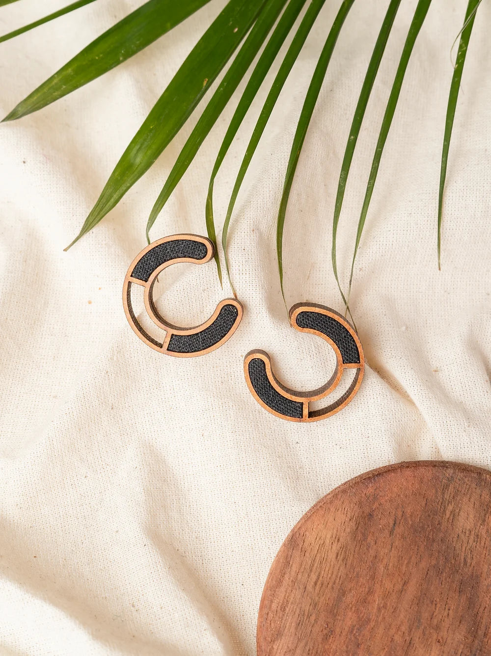 Compassion earrings featuring wood and fabric fusion in contemporary studs.