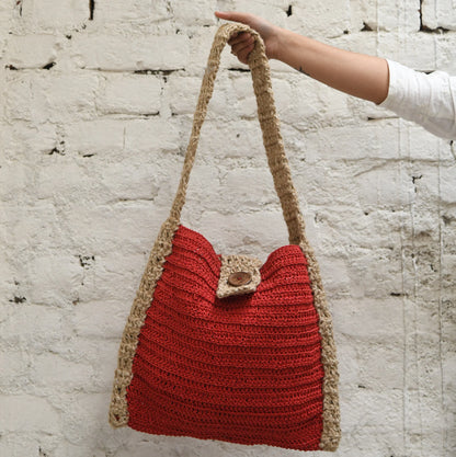 hobo bag, intricately crocheted from premium acrylic yarn. The addition of a stylish wooden button closure