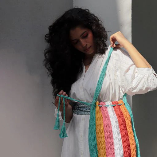 Upgrade your everyday essentials with this hand-crocheted 100% cotton tote, featuring a convenient drawstring closure and a vibrant rainbow palette.