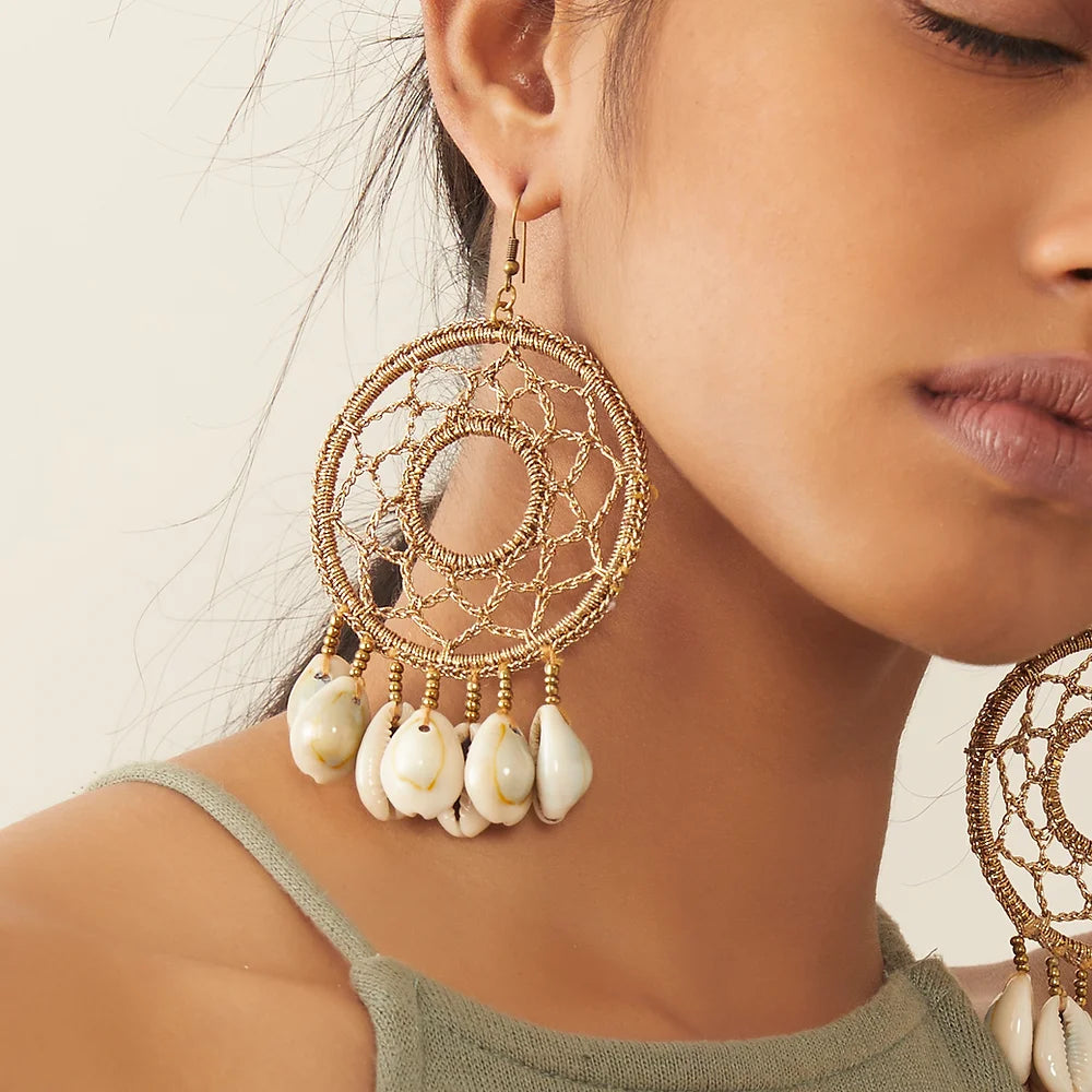 Handcrafted crochet earrings in mesmerizing bronze hue, adorned with delicate white shells.