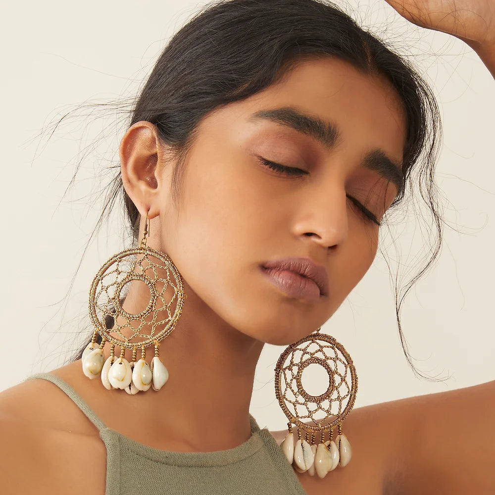 Trendy crochet earrings showcasing stunning bronze hue and graceful white shell adornments.