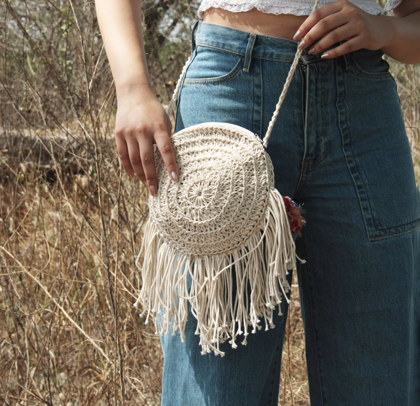 round cotton bag, meticulously crafted with 100% cotton yarn and adorned with recycled textile waste bobbles