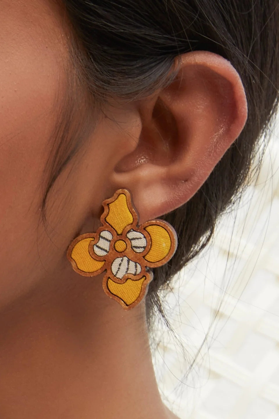 Eco-conscious flower studs handcrafted in sustainable materials, radiating vibrant yellow color.